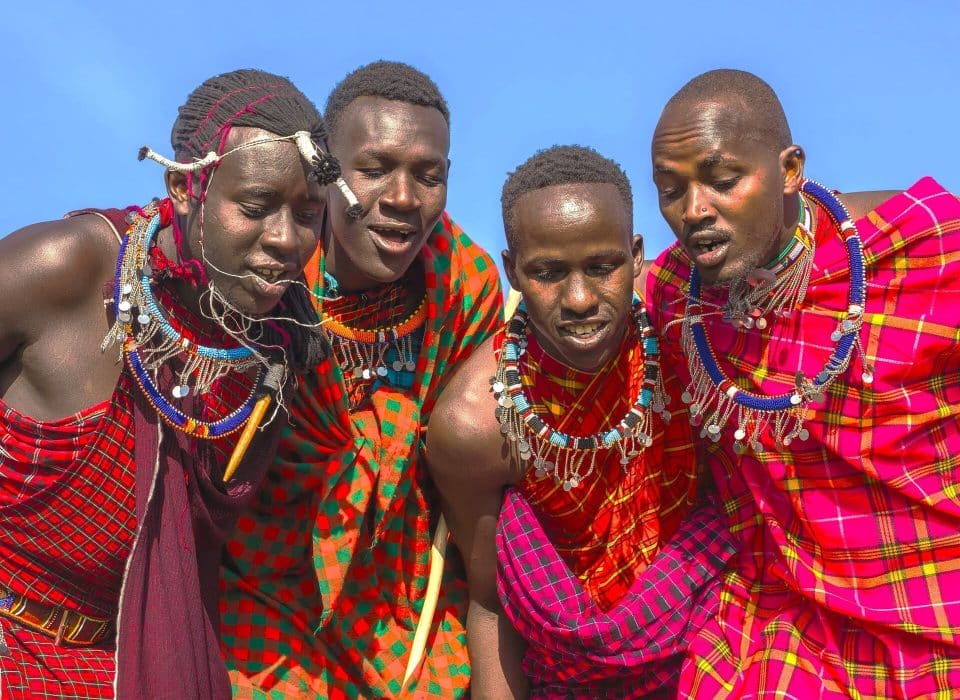 4 African natives doing a traditional Maasai jumping dance