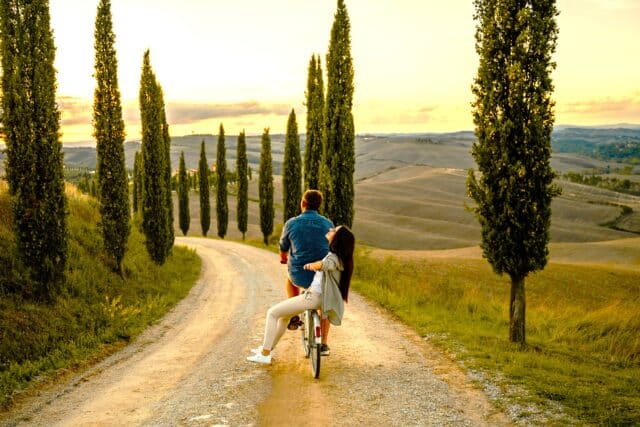 couple bike riding in tuscany